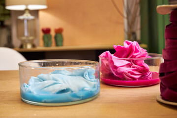 on a table in the workshop are glass flasks with dyed multicolored fabrics, side view