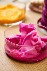 side view of glass flasks with dyed bright fuchsia-colored fabrics, closeup