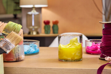 on a table in the workshop are glass flasks with dyed multicolored fabrics, side view