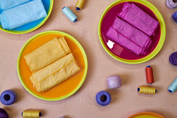 bright background for needlework, dyed colorful fabrics and skeins of thread lying on the table