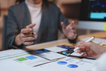 Business colleagues engaging in discussions about financial data while analyzing charts and graphs that illustrate company performance during a collaborative meeting in the office