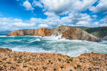Attractive view of cliffs in valley Cala Domestica  and storm on the sea