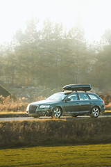 Fototapeta premium Travel SUV with roof cargo box on scenic drive