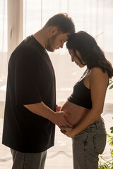 Fototapeta premium Intimate Moment of Expecting Parents by the Window