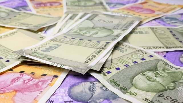 Close up view of rotating Indian rupees (INR), brand new notes. Concept of saving money for retirement, cash settlement, financial success, literacy and income planning in India.