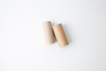 two empty cardboard tube, recycled toilet paper rolls for use in craft project, top down view on white background, step in creative process