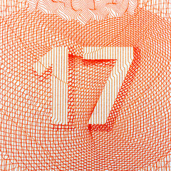Close-up of intricate orange number 17 design on white background.
