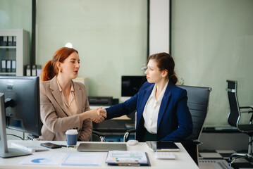 Businesswoman leading team meeting and using tablet and laptop computer with financial