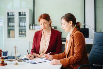 Professional female lawyers consulting on legal cases in a modern office. Perfect for law, business, justice
