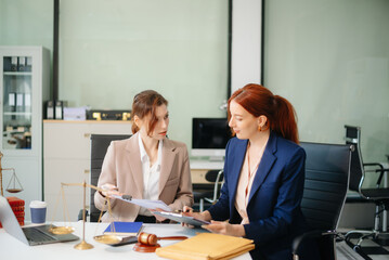 Professional female lawyers consulting on legal cases in a modern office. Perfect for law, business, justice
