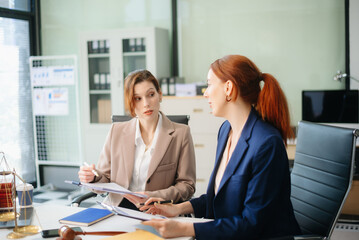 Professional female lawyers consulting on legal cases in a modern office. Perfect for law, business, justice