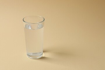 Glass of water on color background