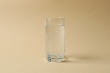 Glass of water on color background