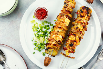 Potatoes with bacon on skewers, summer barbecue.