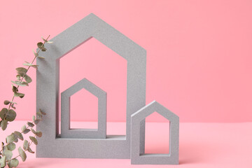 Decorative house shaped frames with eucalyptus branches on pink background