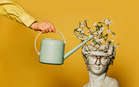 Antique statue of a young man being watered from a watering can