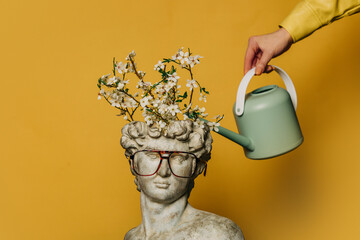 Antique statue of a young man being watered from a watering can
