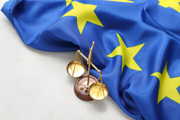 Scales of justice and flag of European Union on white table