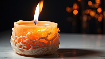 A lit candle with a bright orange flame sits atop a white surface
