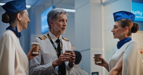 Flight Crew: Mature Airline Pilot Communicating with Two Beautiful Flight Attendants in Uniforms,...