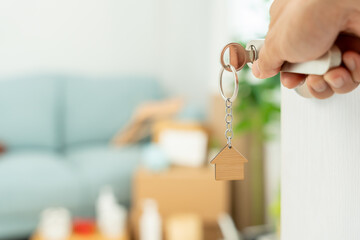 Moving house, relocation. Couple hold key house keychain in new apartment, inside the room was a...