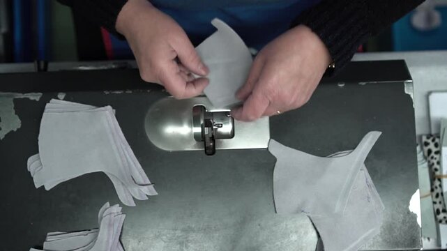 Upview shot that shows female hands working with pieces of fabric.