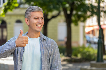 Like. Happy mature man raises thumbs up agrees with something gives positive reply recommends...
