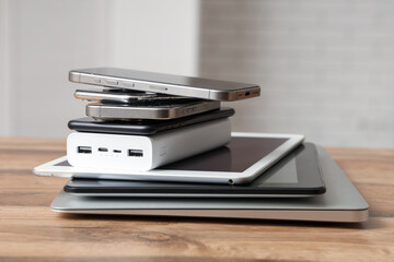 Stack of modern gadgets on wooden table in workshop