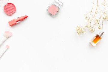 Makeup cosmetic products in brown pink shades - powder, blush and lipstick with perfume, top view