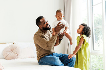 Authentic diverse family celebrating Father's Day at home—loving dad enjoying joyful moments with his daughters, reflecting warmth, connection, and appreciation in modern parenting life.