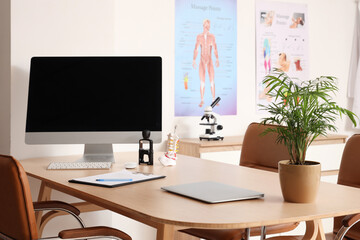 Doctor's workplace with computer monitor and laptop in medical office