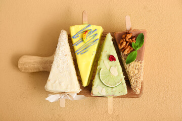 Board with tasty cheesecake pops on beige background