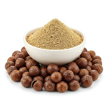 A bowl of Organic Soapnuts or Reetha (Sapindus mukorossi) powder, placed over a heap of Soapnuts berries. Isolated on a white background