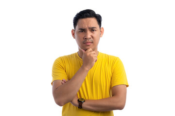 Handsome Asian man holding his chin, looking at the camera with suspicion expression isolated on...