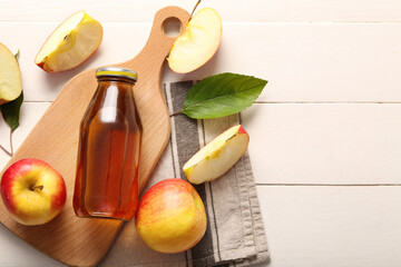 Bottle of fresh apple juice on white wooden background