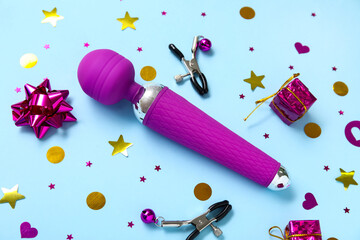 Composition with vibrator, nipple clamps and decorations on color background