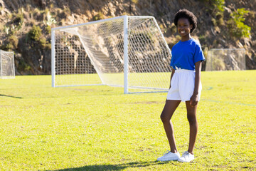 Obraz premium On soccer field, smiling african american girl in sports, copy space