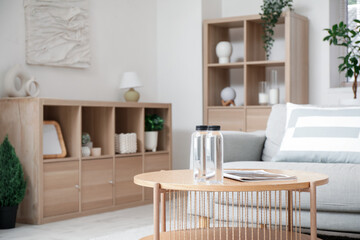 Bottles of water and magazine on table in living room, closeup