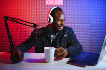 Handsome Young African American Man Talking Into Microphone While Recording Radio Show
