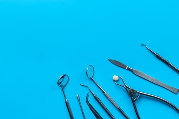 Dental teeth crowns and steel instruments for dental prosthetics, top view. Dentist desk