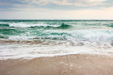 seascape in morning light. bad vacation season background. tide and foam on the shoreline. stormy...
