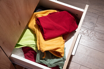folded clothes are in the drawer of the wardrobe