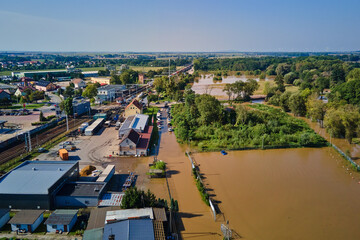 Aerial view of flooded streets, railway tracks and buildings in a suburban area. Industrial zone...