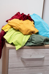 pile of clothes lies in the open drawers of the closet. Scattered things around