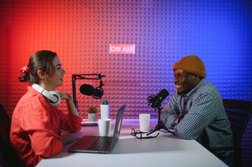 Man and woman livestreaming online discussion on podcast episode, recording live for internet...