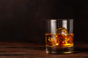 A classic whiskey glass filled with golden amber whiskey
