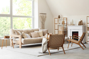 Stylish interior of living room with sofa, rattan armchairs and coffee table