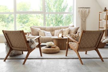 Cozy sofa, armchairs and coffee table in interior of living room