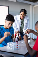 In school, students conducting science experiment with test tubes and microscope