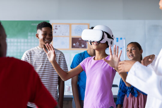 Using VR headset, students in school classroom exploring virtual reality together